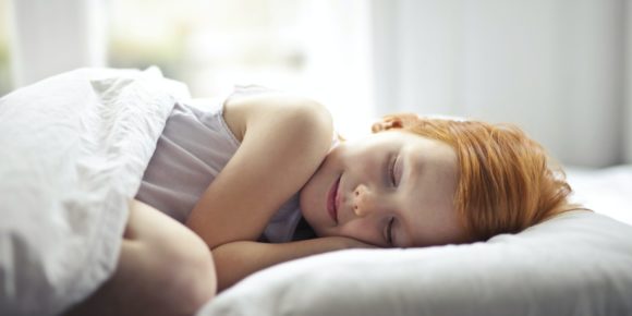 girl sleeping on a bed scaled