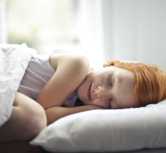 girl sleeping on a bed scaled